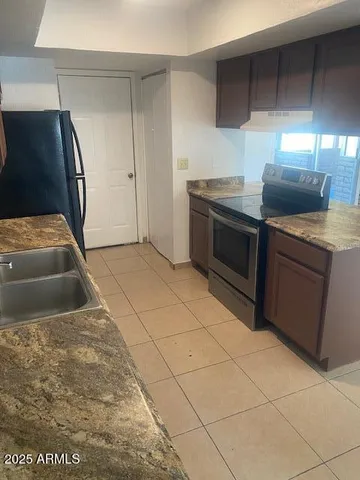 a kitchen with stainless steel appliances granite countertop a stove a sink and a refrigerator