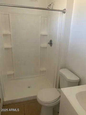 a white toilet sitting next to a bath tub