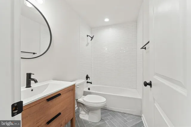 a bathroom with a sink a toilet and a mirror