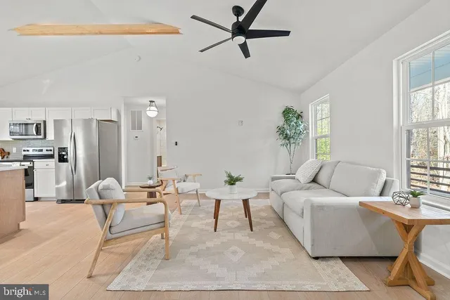 a living room with furniture and a ceiling fan