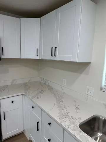a kitchen with white cabinets and a sink