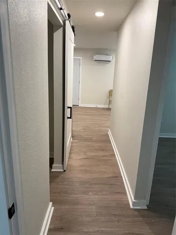 a view of a hallway with wooden floor and staircase