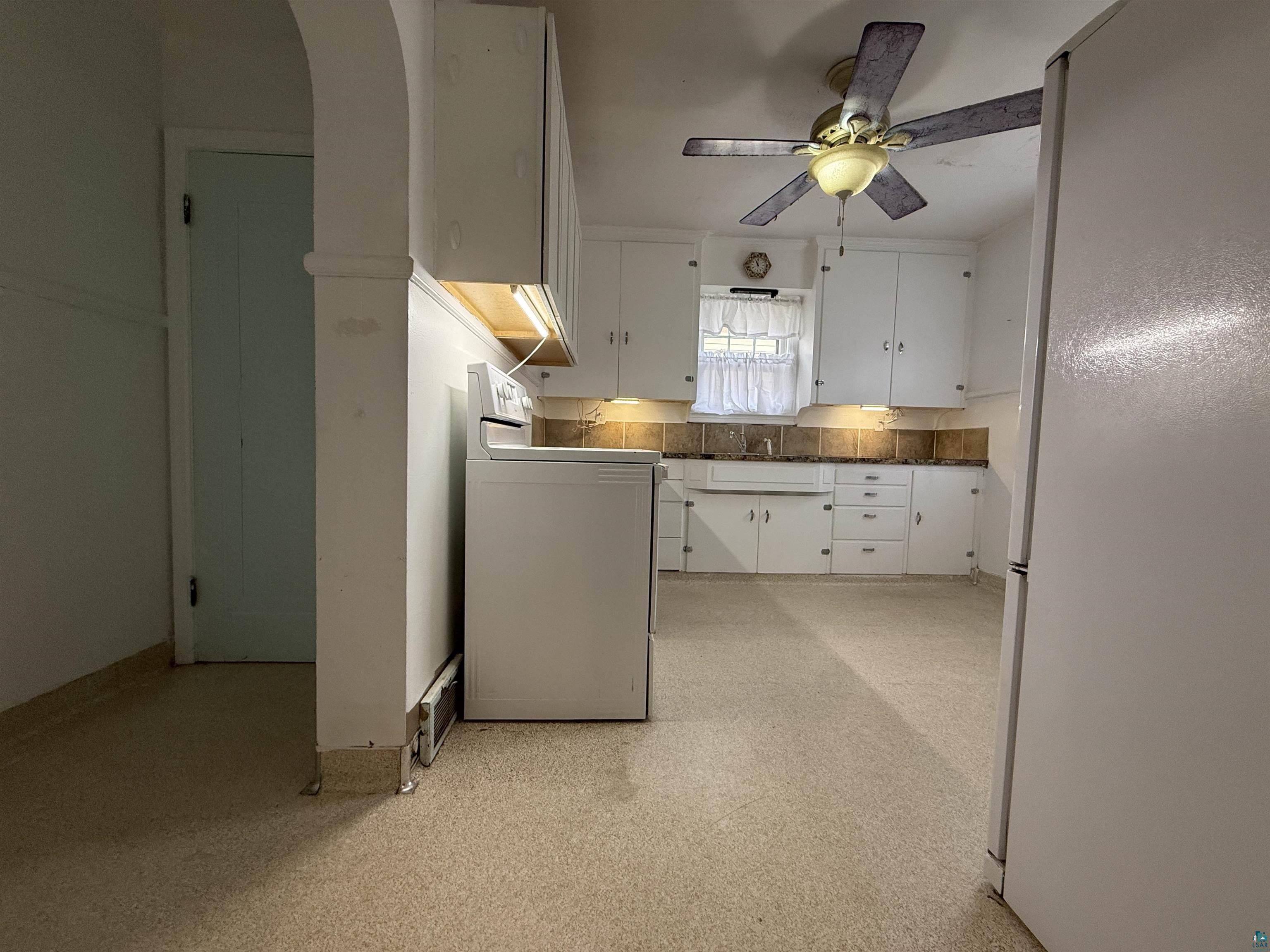 3001 3rd Avenue West Hibbing, MN 55746 - Photo 14 of 38 Kitchen with freestanding refrigerator, washer / clothes dryer, white cabinetry, light floors, and a ceiling fan