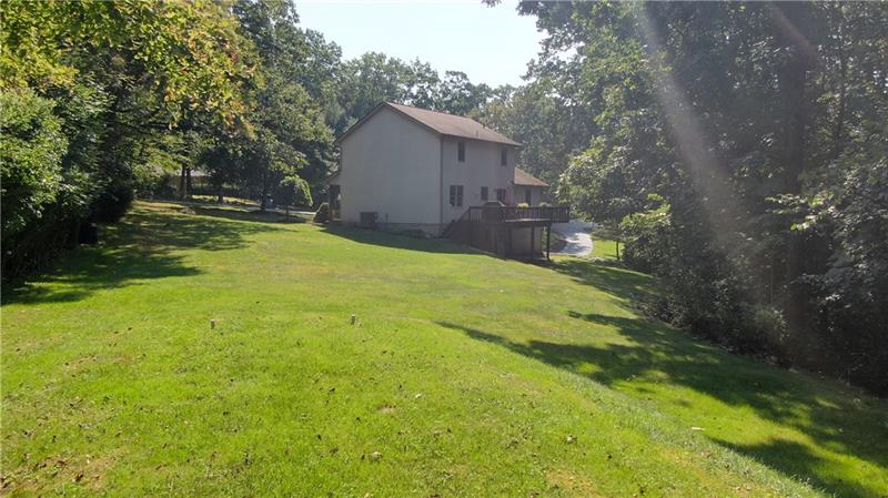 7965 Franklin Road Evans City, PA 16033 - Photo 22 of 25 The rear of the home features an over sized deck accessible from the eat in kitchen and a walk out lower level to a patio and lush yard.