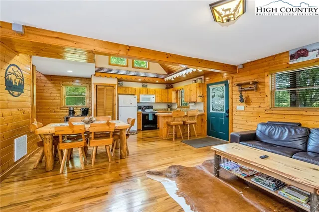 a living room with a couch a dining table and chairs with wooden floor