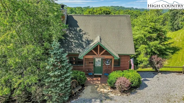 a view of a house with a yard and potted plants