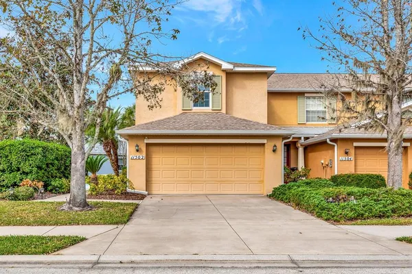 a front view of a house with a yard and trees