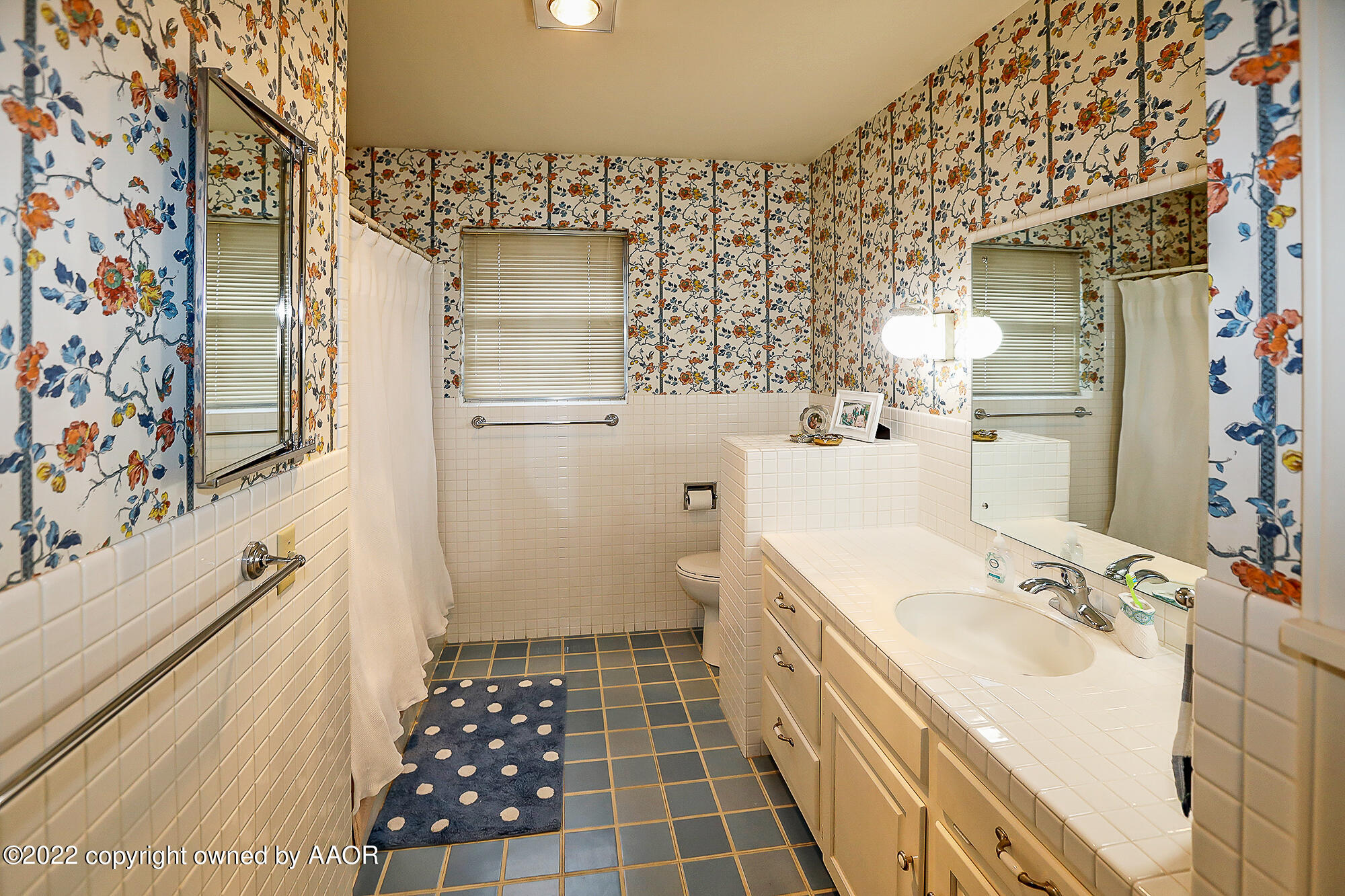 6303 Calumet Road Amarillo, TX 79106 - Photo 22 of 31 a bathroom with a sink a toilet a shower and a mirror