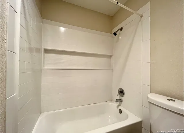 a bathroom with a bathtub and a toilet