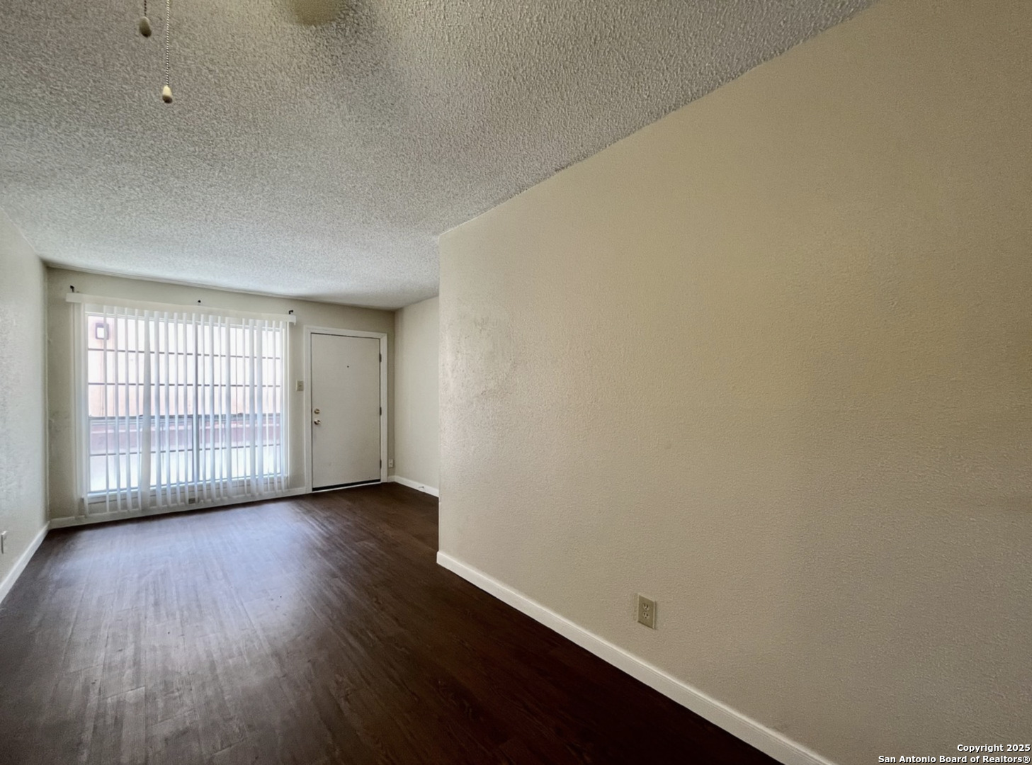 3243 Nacogdoches Road, Unit 404 San Antonio, TX 78217 - Photo 6 of 16 a view of an empty room with wooden floor and a window
