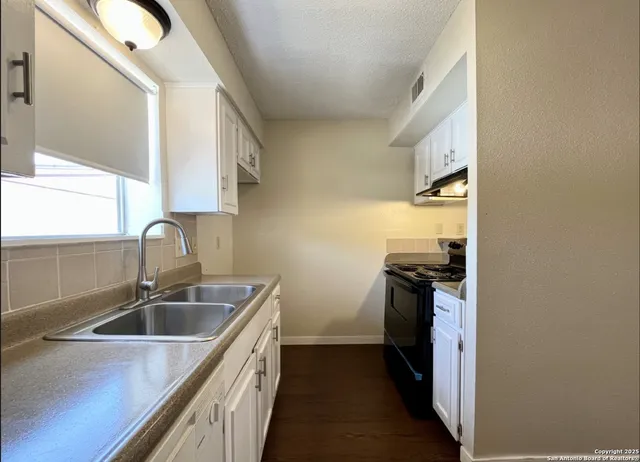 a kitchen that has a sink and a stove