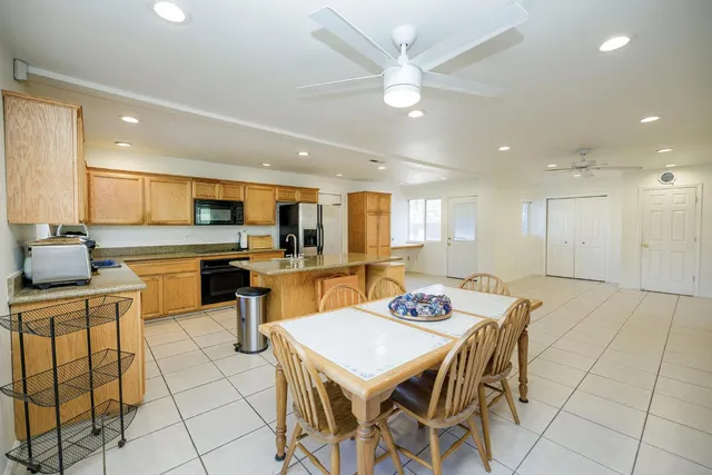 a kitchen with a dining table chairs and white cabinets