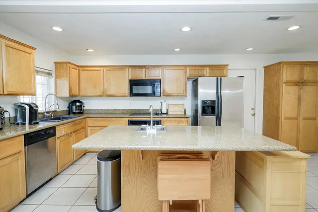 a kitchen with stainless steel appliances granite countertop a sink a stove and a refrigerator