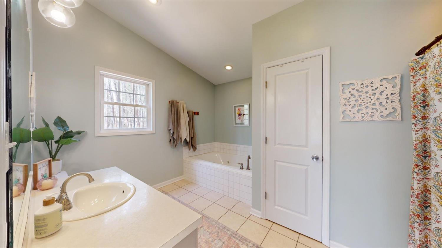 120 Ripley Drive Danville, VA 24540 - Photo 43 of 71 a bathroom with a granite countertop sink a mirror a bathtub and next to a window