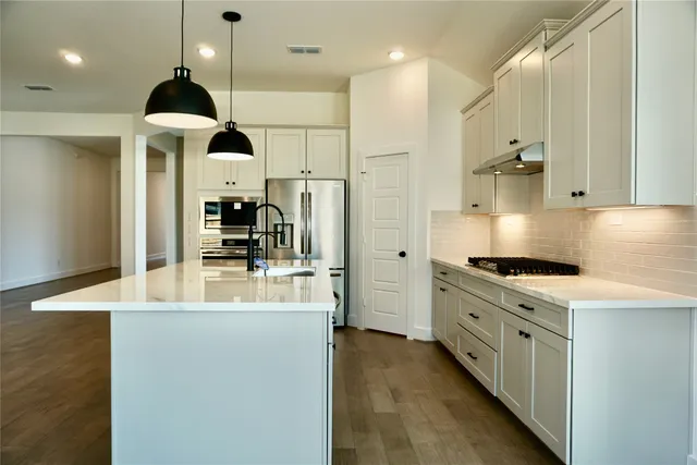 a kitchen with stainless steel appliances kitchen island a stove a sink a refrigerator and a refrigerator