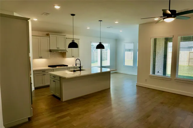 a kitchen with kitchen island stainless steel appliances a sink a counter top space and a window