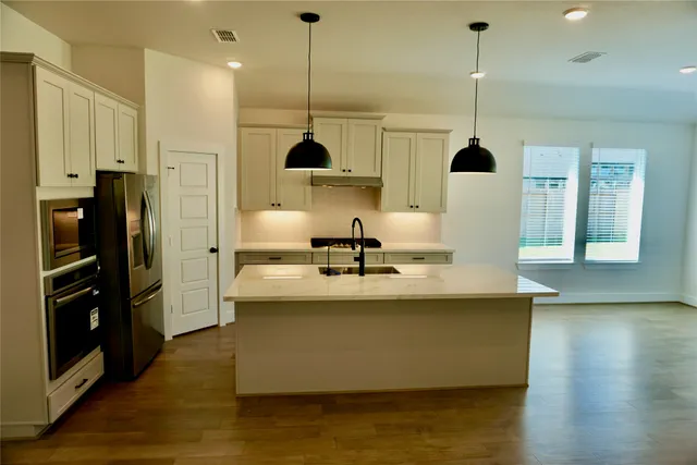 a view of kitchen with stainless steel appliances kitchen island sink refrigerator and stove