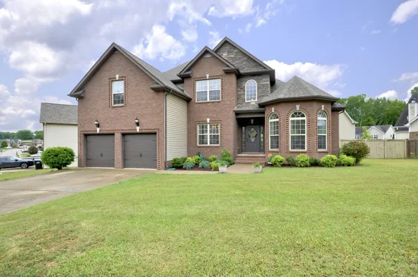 a front view of a house with a yard and garage