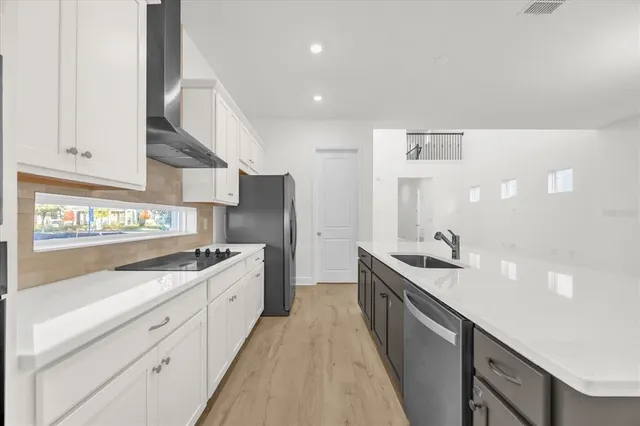 a kitchen with white cabinets and sink