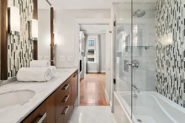 a bathroom with a granite countertop sink and a bathtub
