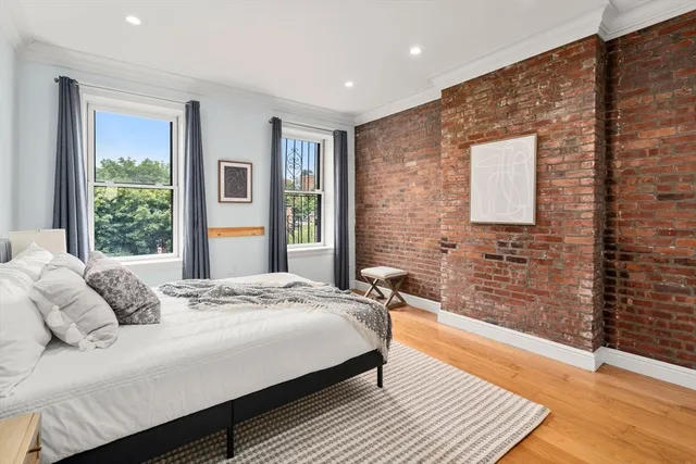 a bedroom with a bed wooden floor and window