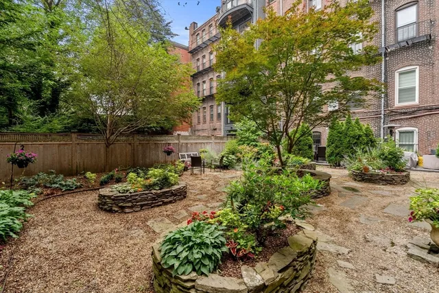 a backyard with table and chairs and potted plants