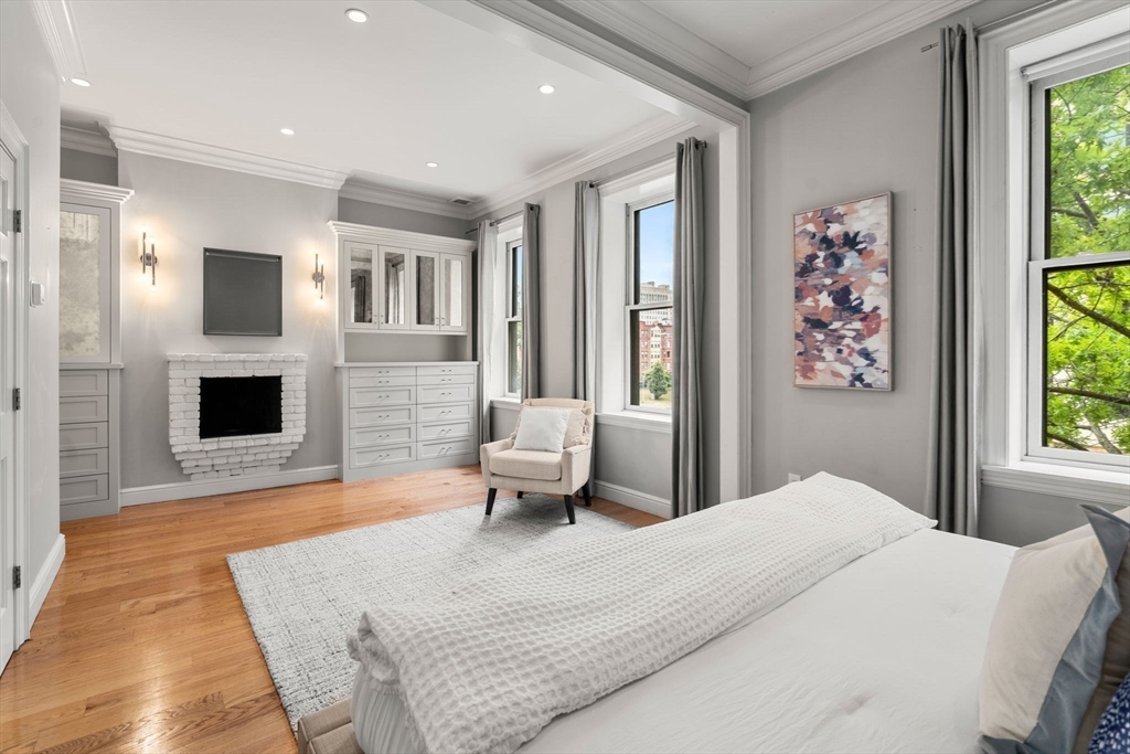 82 Berkeley Street, Unit 5 Boston, MA 02116 - Photo 9 of 32 a bedroom with a large bed and a fireplace