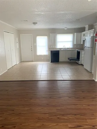 a view of empty room with a kitchen and a sink