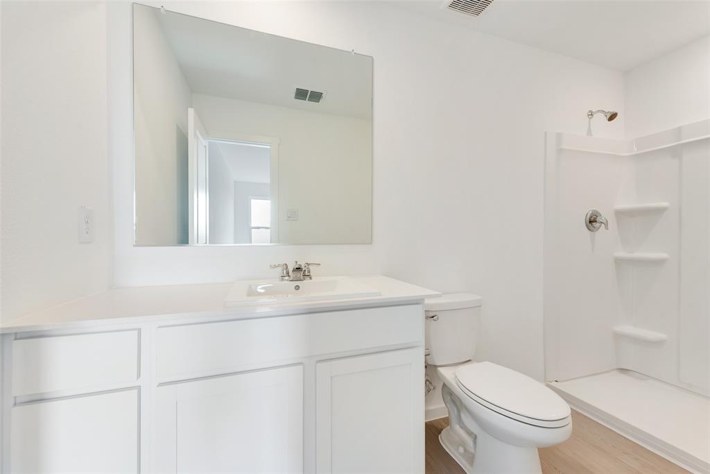 3612 Oleander Place Sherman, TX 75092 - Photo 20 of 21 a bathroom with a toilet a sink a mirror and a shower