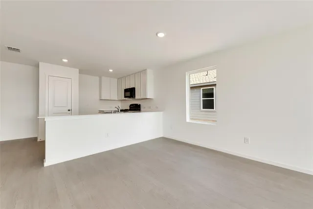 a view of kitchen with kitchen island sink microwave and cabinets