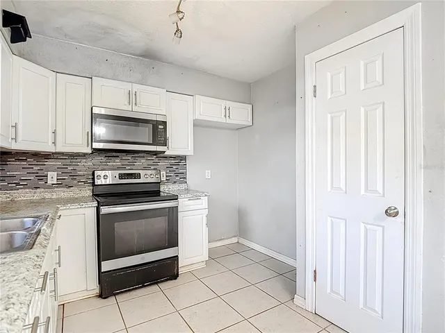 a kitchen with granite countertop a stove microwave and cabinets