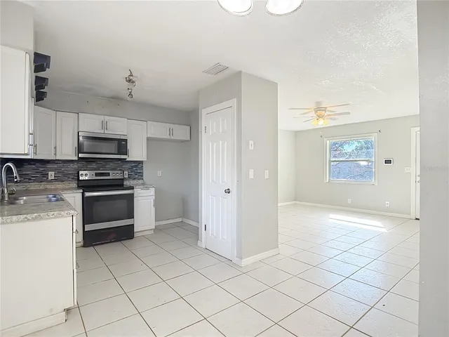 a kitchen with granite countertop a sink cabinets and stainless steel appliances