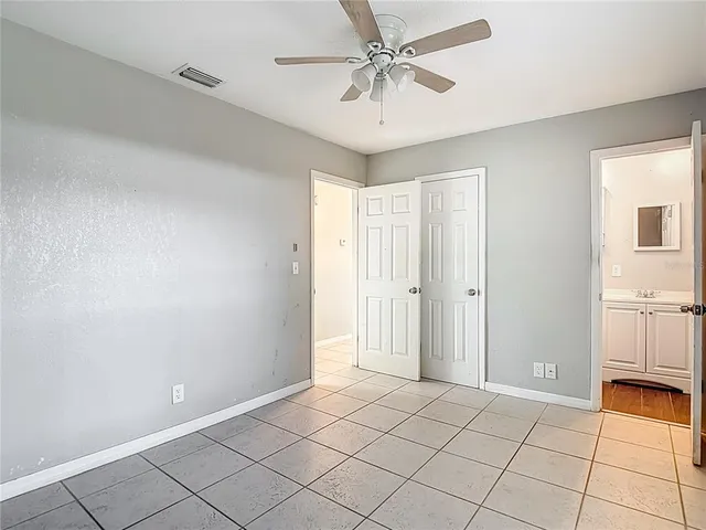 a view of a livingroom with a chandelier fan and windows