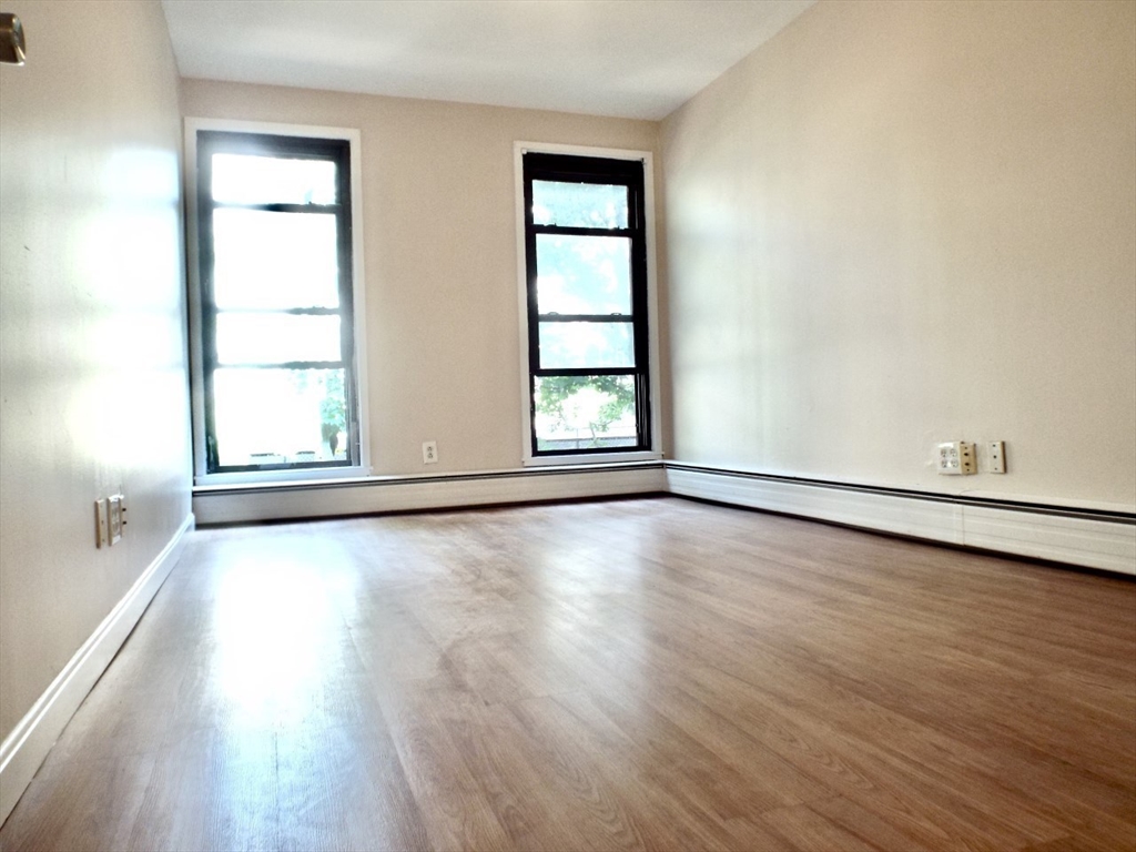 32 Juniper Street, Unit 98 Brookline, MA 02445 - Photo 8 of 17 an empty room with wooden floor and windows