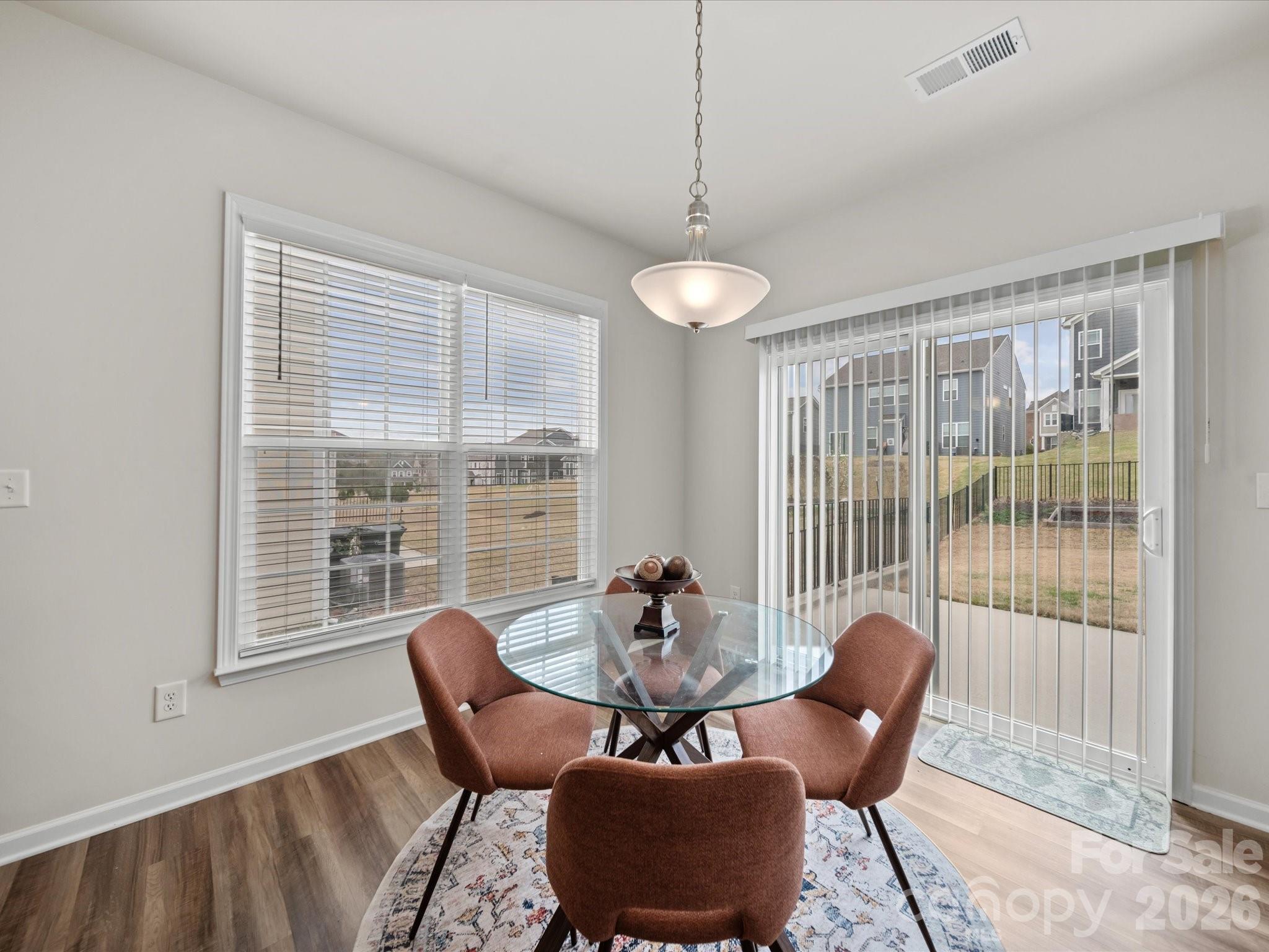 9582 Creighton Road Northwest Concord, NC 28027 - Photo 12 of 43 a dining room with furniture a chandelier and wooden floor