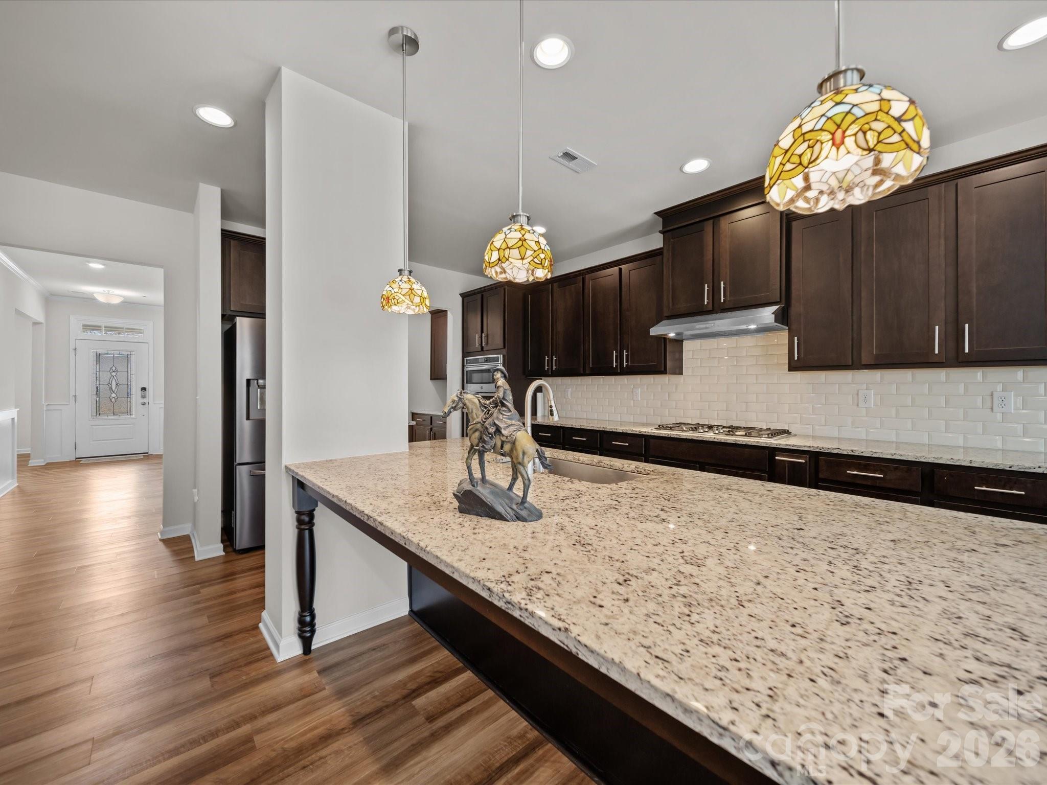 9582 Creighton Road Northwest Concord, NC 28027 - Photo 13 of 43 a kitchen with stainless steel appliances granite countertop a sink window and wooden floor