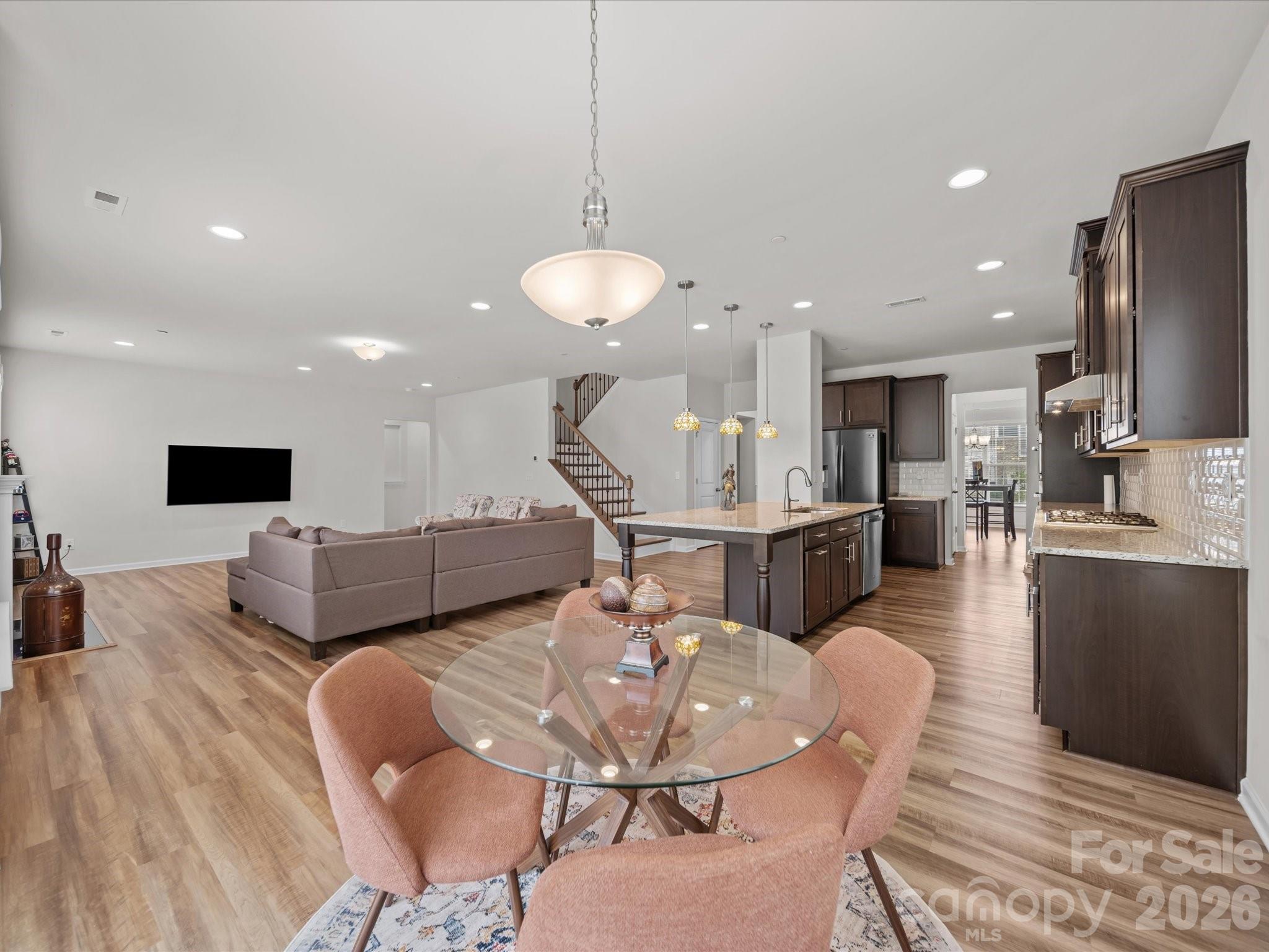 9582 Creighton Road Northwest Concord, NC 28027 - Photo 14 of 43 a dining room with furniture a wooden floor and a chandelier
