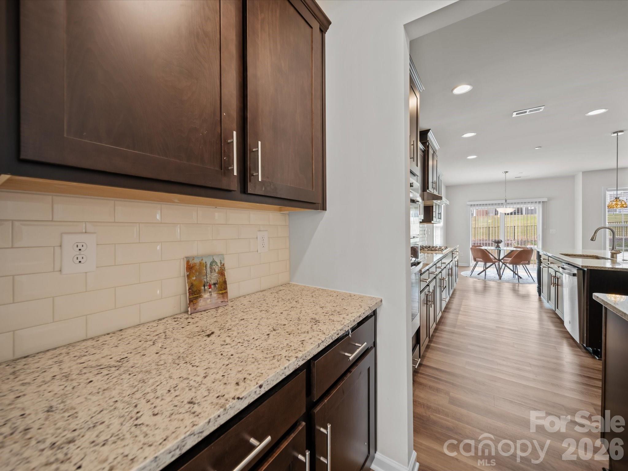 9582 Creighton Road Northwest Concord, NC 28027 - Photo 6 of 43 a kitchen with granite countertop a coffee maker on granite counter tops and white cabinets