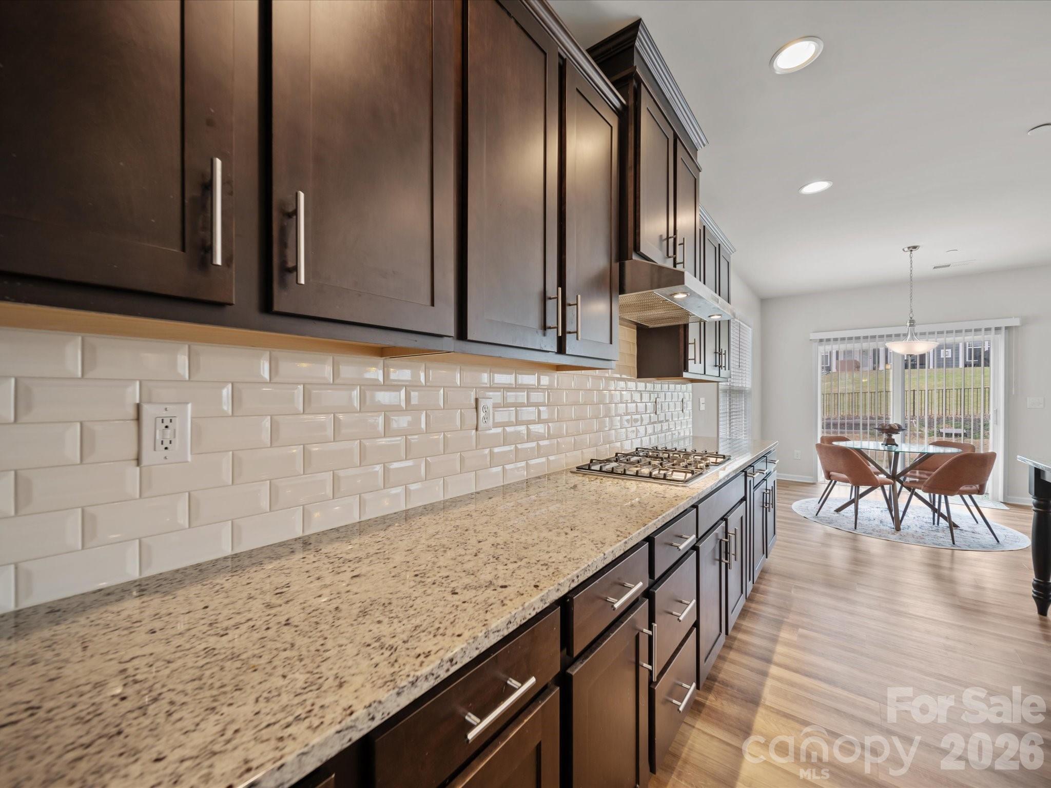 9582 Creighton Road Northwest Concord, NC 28027 - Photo 7 of 43 a kitchen with granite countertop a stove a sink and a microwave