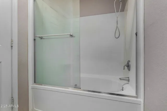 an empty room with windows and ceiling fan