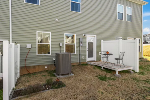 a view of a patio with table and chairs with wooden floor and fence