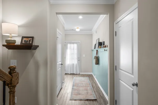 a view of a hallway with a livingroom and a bathroom with sink mirror