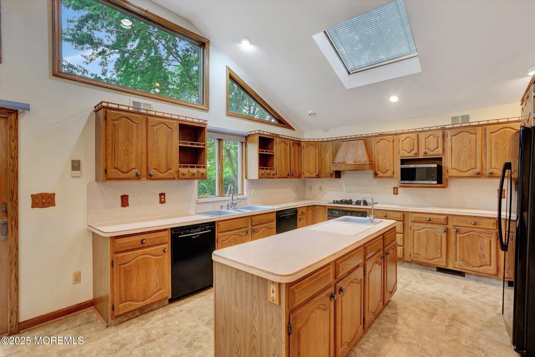 159 Koster Drive Freehold, NJ 07728 - Photo 11 of 37 a kitchen with stainless steel appliances granite countertop a sink a stove top oven a refrigerator with white cabinets and wooden floor