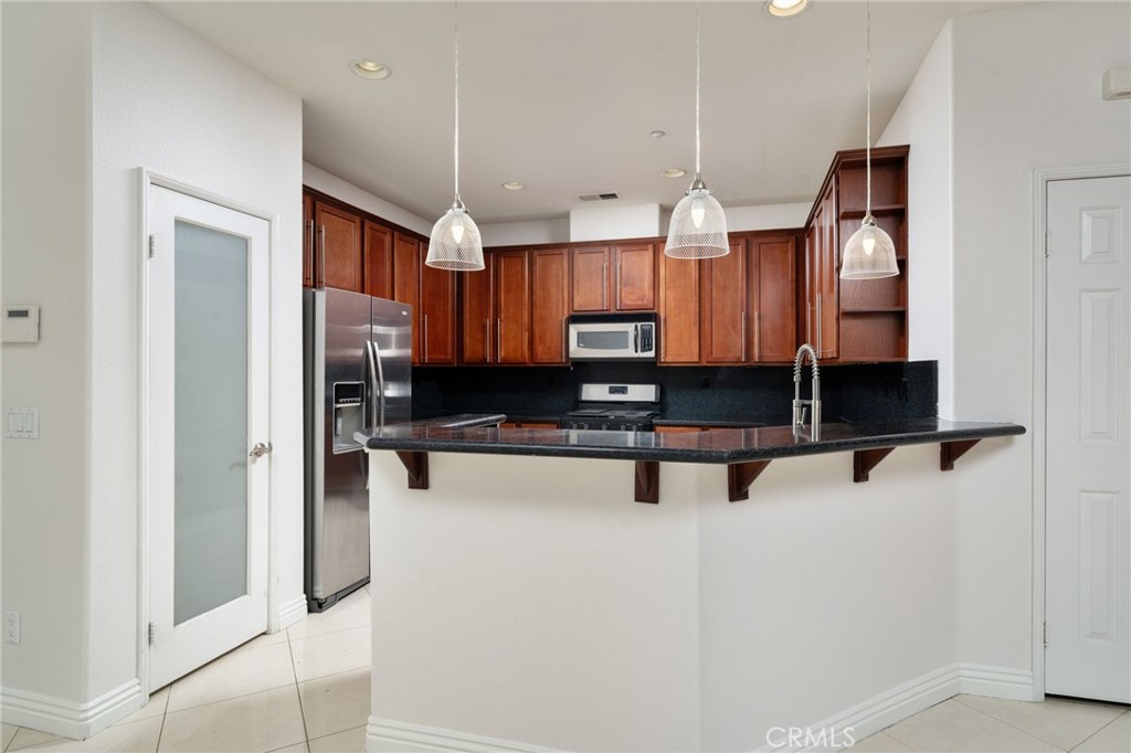 7331 Shelby Place, Unit 102 Rancho Cucamonga, CA 91739 - Photo 11 of 44 a kitchen with stainless steel appliances granite countertop a refrigerator and a sink