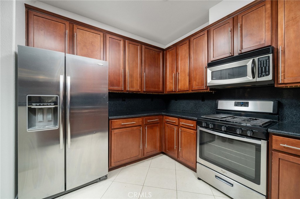 7331 Shelby Place, Unit 102 Rancho Cucamonga, CA 91739 - Photo 13 of 44 a kitchen with granite countertop stainless steel appliances and wooden cabinets