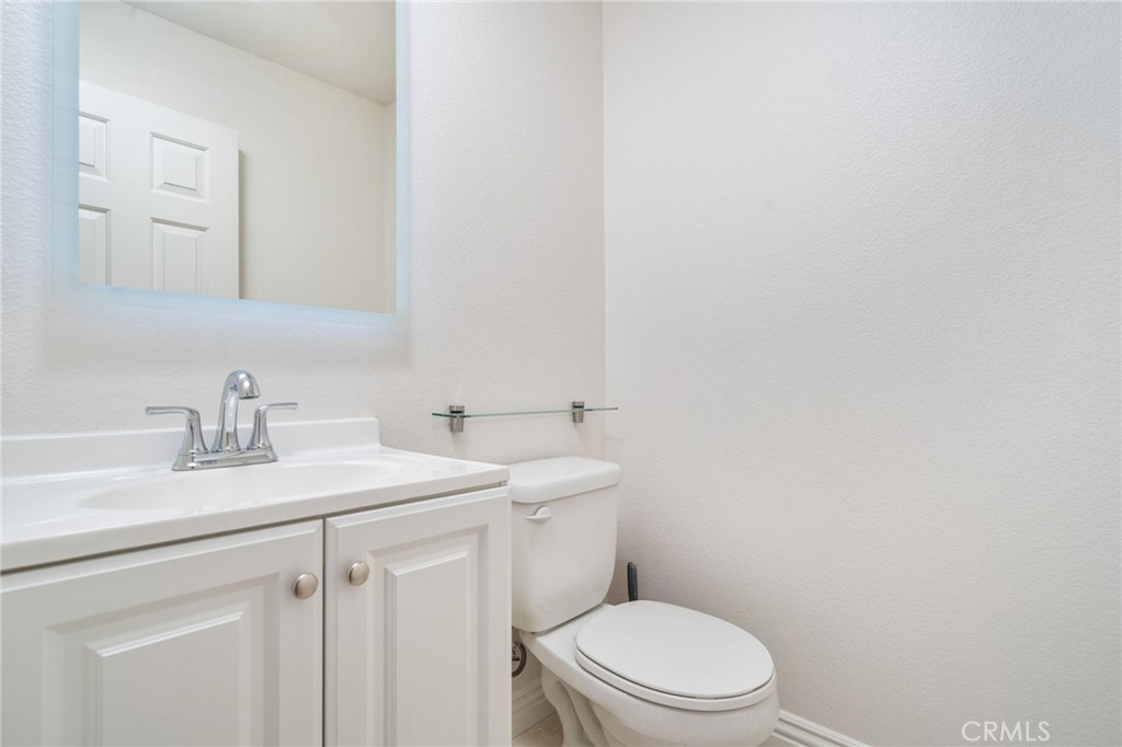 7331 Shelby Place, Unit 102 Rancho Cucamonga, CA 91739 - Photo 16 of 44 a bathroom with a granite countertop toilet sink and mirror