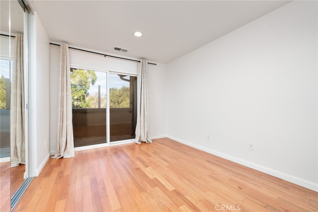7331 Shelby Place, Unit 102 Rancho Cucamonga, CA 91739 - Photo 20 of 44 a view of an empty room with wooden floor and a window