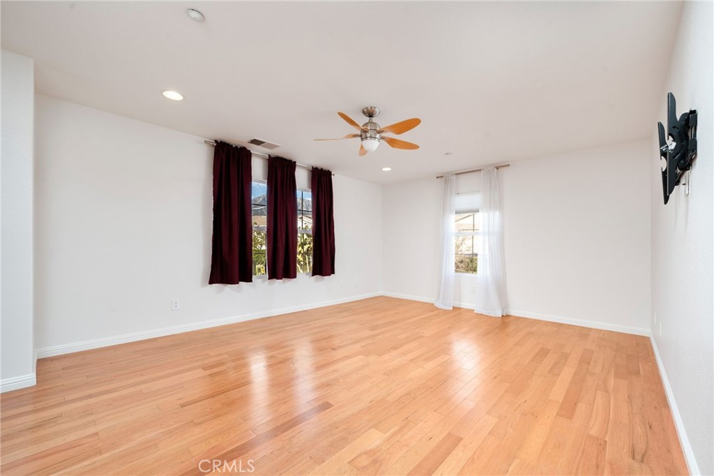 7331 Shelby Place, Unit 102 Rancho Cucamonga, CA 91739 - Photo 24 of 44 a view of a room with a ceiling fan and wooden floor