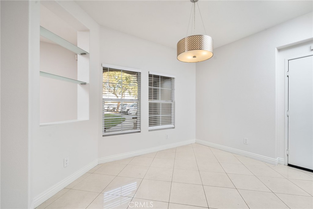 7331 Shelby Place, Unit 102 Rancho Cucamonga, CA 91739 - Photo 10 of 44 an empty room with windows and a chandelier fan