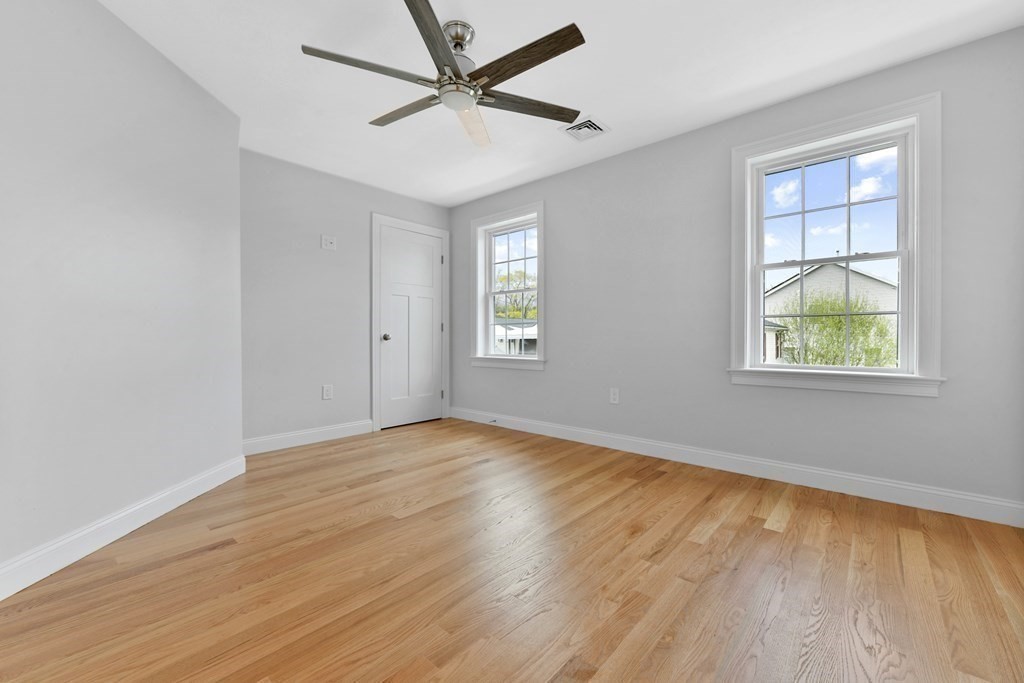 35 Roosevelt Road Dedham, MA 02026 - Photo 36 of 40 an empty room with wooden floor ceiling fan and windows